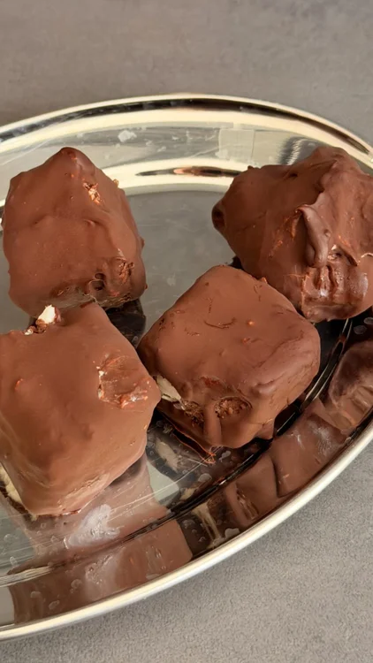 Brownie- Coconut Ice Cubes🤎🤍

Diese Iced Coconut Brownie Cubes schmecken wie kleine Bounty-Brownies aus dem Tiefkühler. Die Kombination aus schokoladigem Bananenboden, cremiger Kokosschicht und knackiger Schokolade macht sie zum perfekten Meal-Prep-Dessert.

Rezept:

Brownie-Schicht:

3 reife Bananen
1 EL Kakao-Proteinpulver von Vetain
1 EL Rohkakao
150–250 ml Kokosmilch (je nach gewünschter Konsistenz)

Kokosschicht:

4 EL Kokosjoghurt
2 EL Süße nach Wahl
2 EL Kokosraspeln
200 ml Kokosmilch
1/2 EL Flohsamenschalen

Außerdem:

150–200 g Zartbitterschokolade zum Überziehen

Zubereitung:

Die Bananen zusammen mit Proteinpulver, Rohkakao und der Kokosmilch zu einer glatten Brownie-Masse pürieren. In eine kleine, mit Backpapier ausgelegte Form füllen und glattstreichen.

Für die Kokosschicht Kokosjoghurt, Süße, Kokosraspeln, Kokosmilch und Flohsamenschalen verrühren. Etwa 10 Minuten quellen lassen und anschließend auf der Brownie-Schicht verteilen.

Die Form für mindestens 3–4 Stunden oder über Nacht in den Tiefkühler stellen.

Anschließend in Würfel schneiden, die Schokolade schmelzen und die Brownie Cubes darin wenden oder damit überziehen.

Kurz erneut kühlen, bis die Schokolade fest geworden ist, und direkt aus dem Kühlschrank oder Tiefkühler genießen.